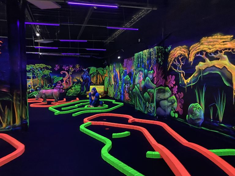 Allée du parcours de mini-golf fluo entre les fresques