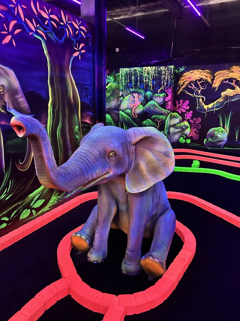 Statue d'éléphant fluo au bord d'une piste rouge