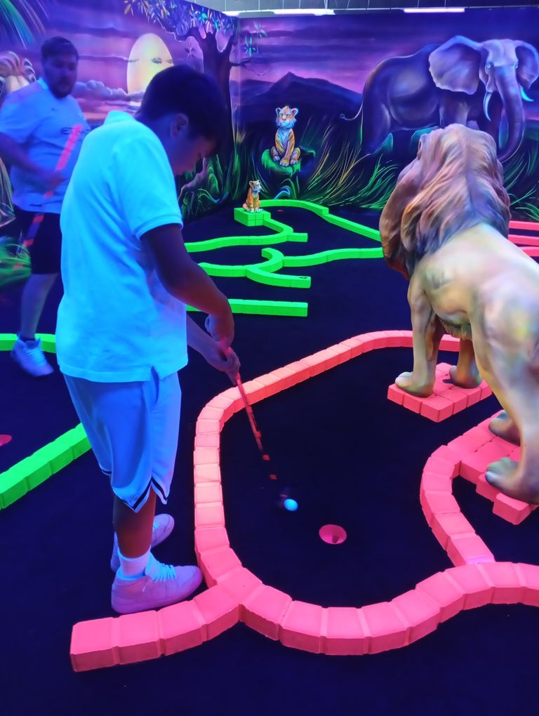 Un groupe de joueurs sur le parcours de mini-golf fluo du Goolfy Merlimont
