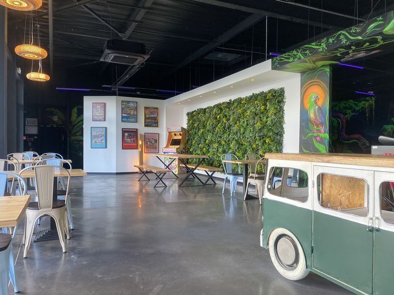 La salle du Goolfy avec ses tables, son bar et sa borne d'arcade