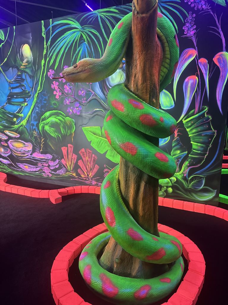 Serpent fluo enroulé autour d'un arbre peint